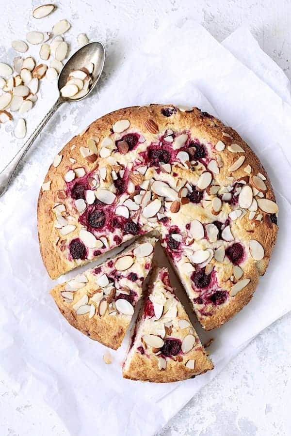Raspberry Ricotta Cake with Almonds and Ricotta Whipped Cream on some parchment paper and cut into slices.