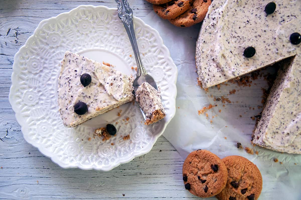 A slice of semifreddo cookies and cream cake on a white plate with cookies and cake to the side.