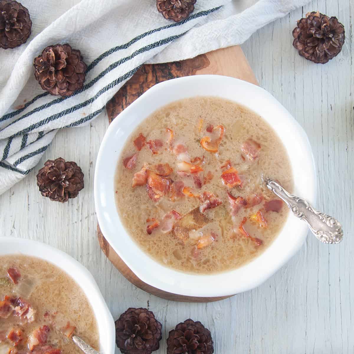 Bowl of sauerkraut soup in a white bowl on a grey table top.