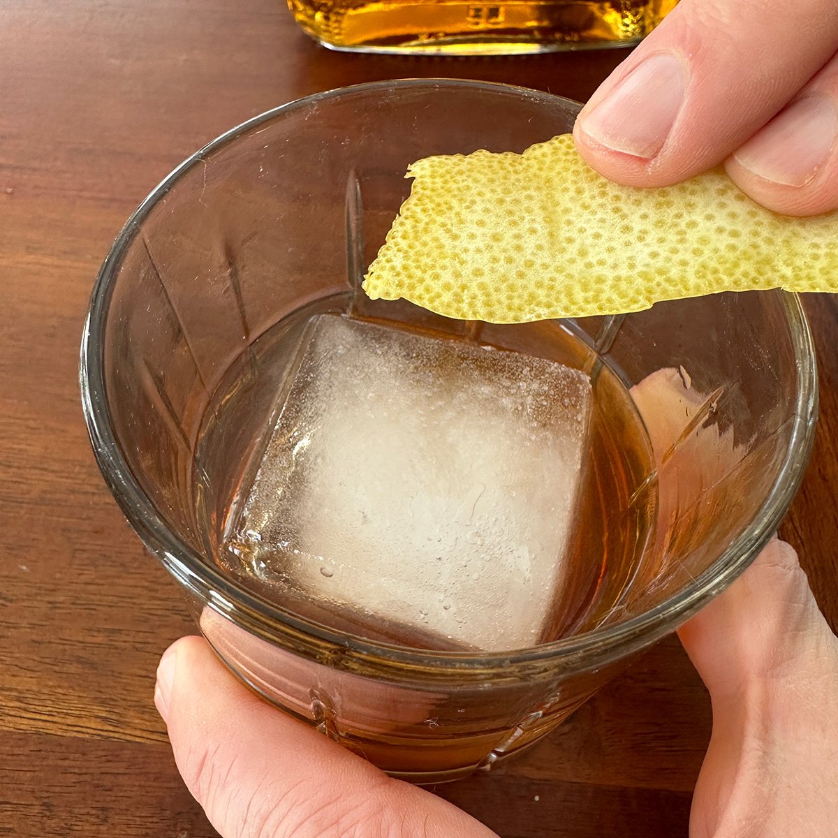 Rubbing a lemon peel on an edge of a glass.