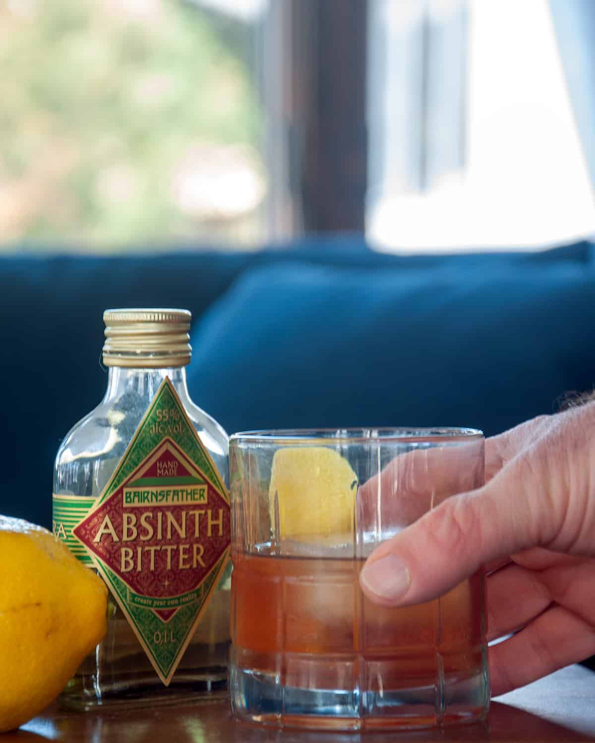 A hand holding a classic Sazerac cocktail!