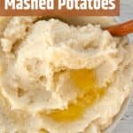 Classic Mashed Potatoes in a bowl with a wooden spoon.