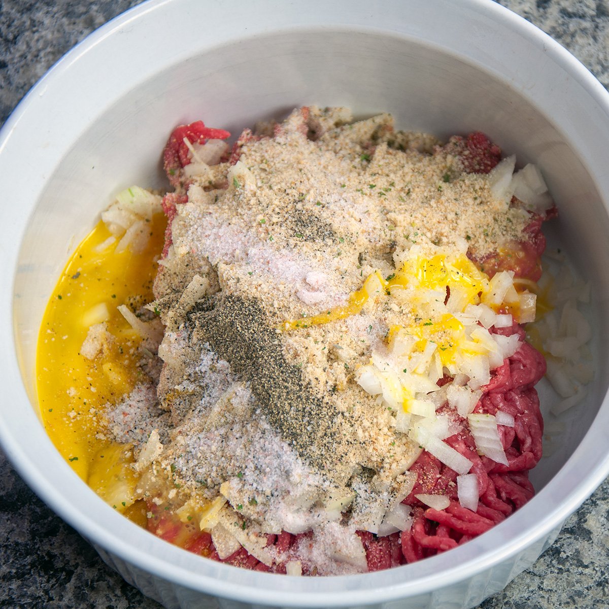 Beef patty ingredients in a white bow.