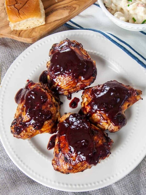 Four grilled chicken thighs with a Homemade BBQ Sauce Recipe.
