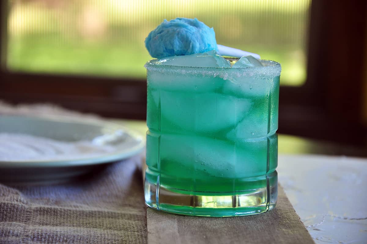 Cotton Candy Margarita on a table with a window in the background.