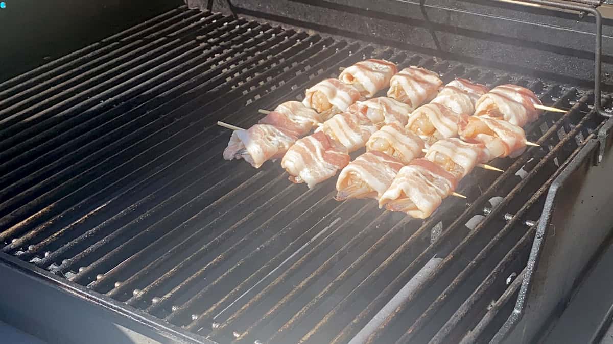 Four skewers of bacon wrapped shrimp.