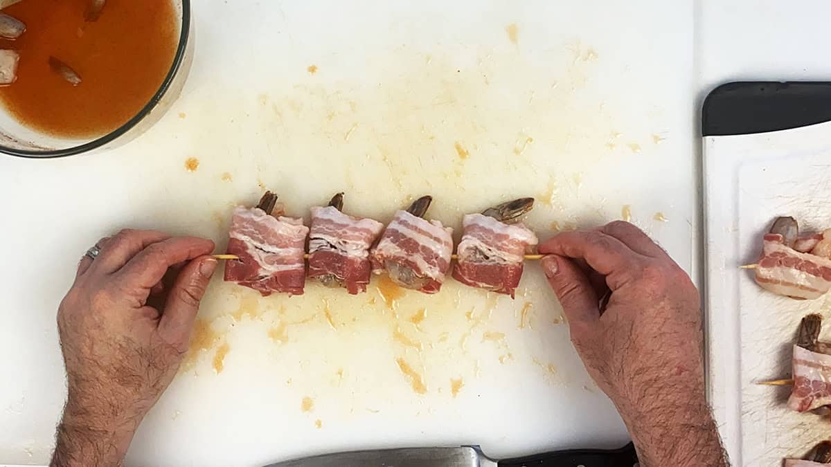 Four shrimp on a wood skewer before putting them on the grill.