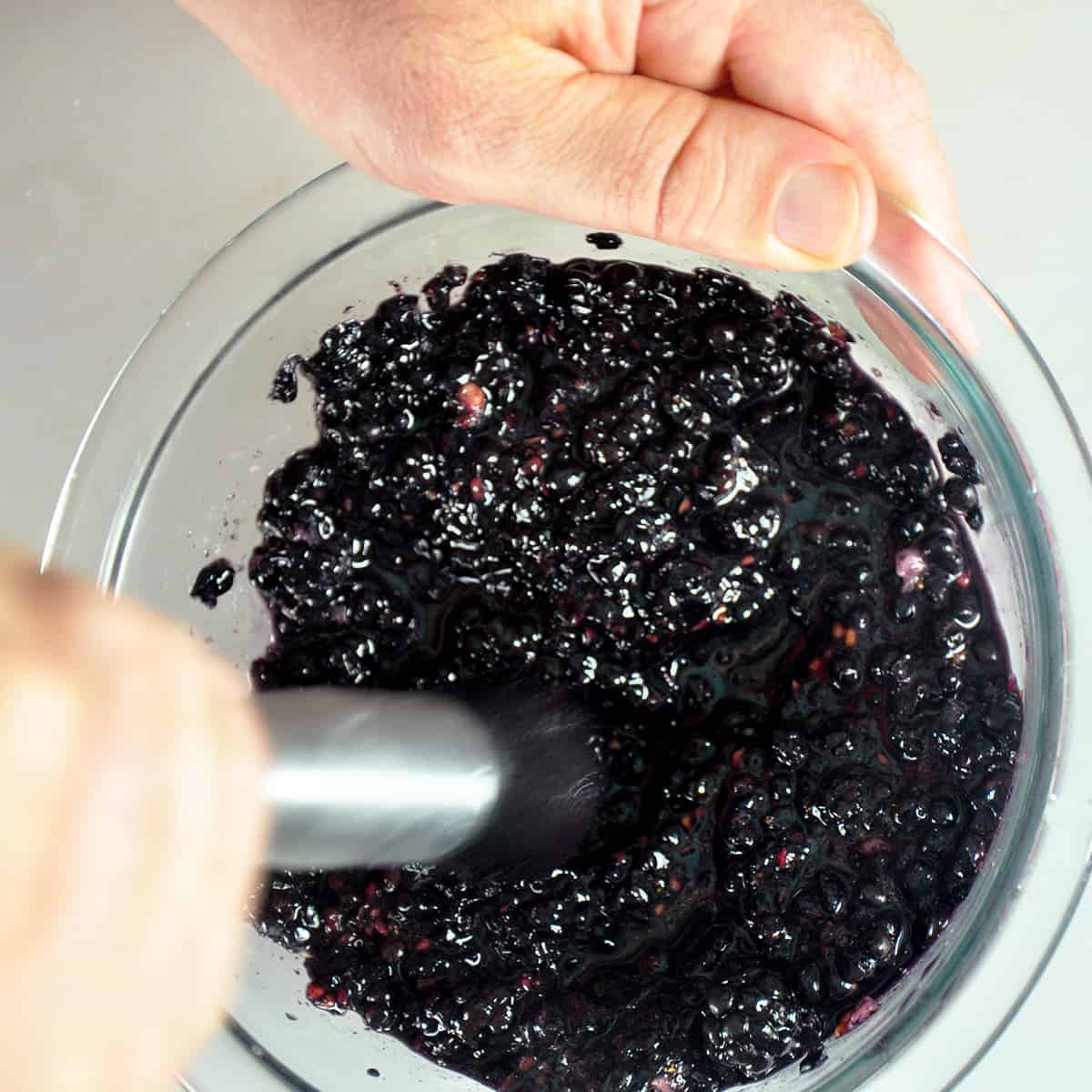 Using a tool to squish blackberries.