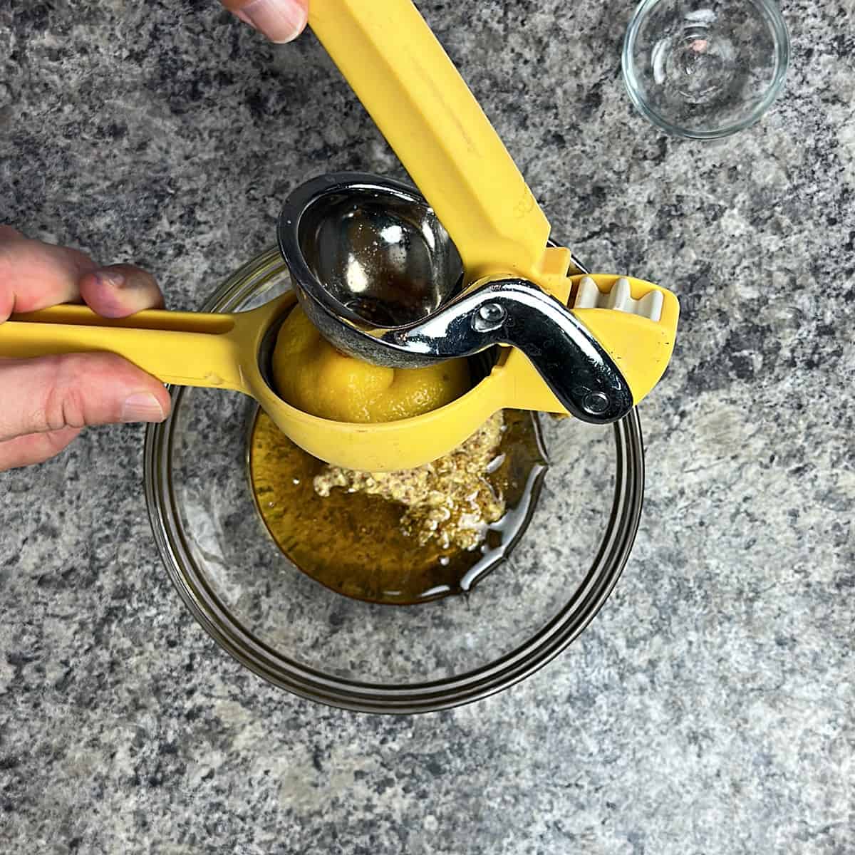 Squeezing lemon into a bowl with honey and mustard.