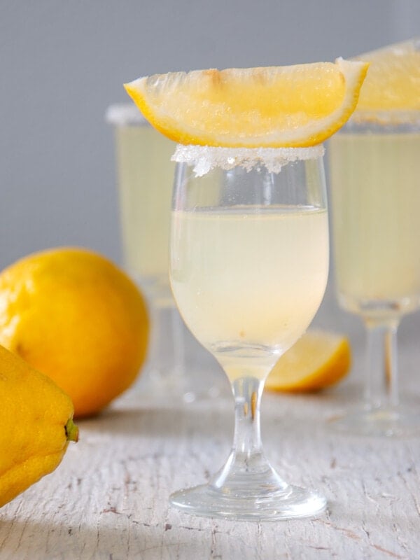 Two lemon drop shots on a white table.