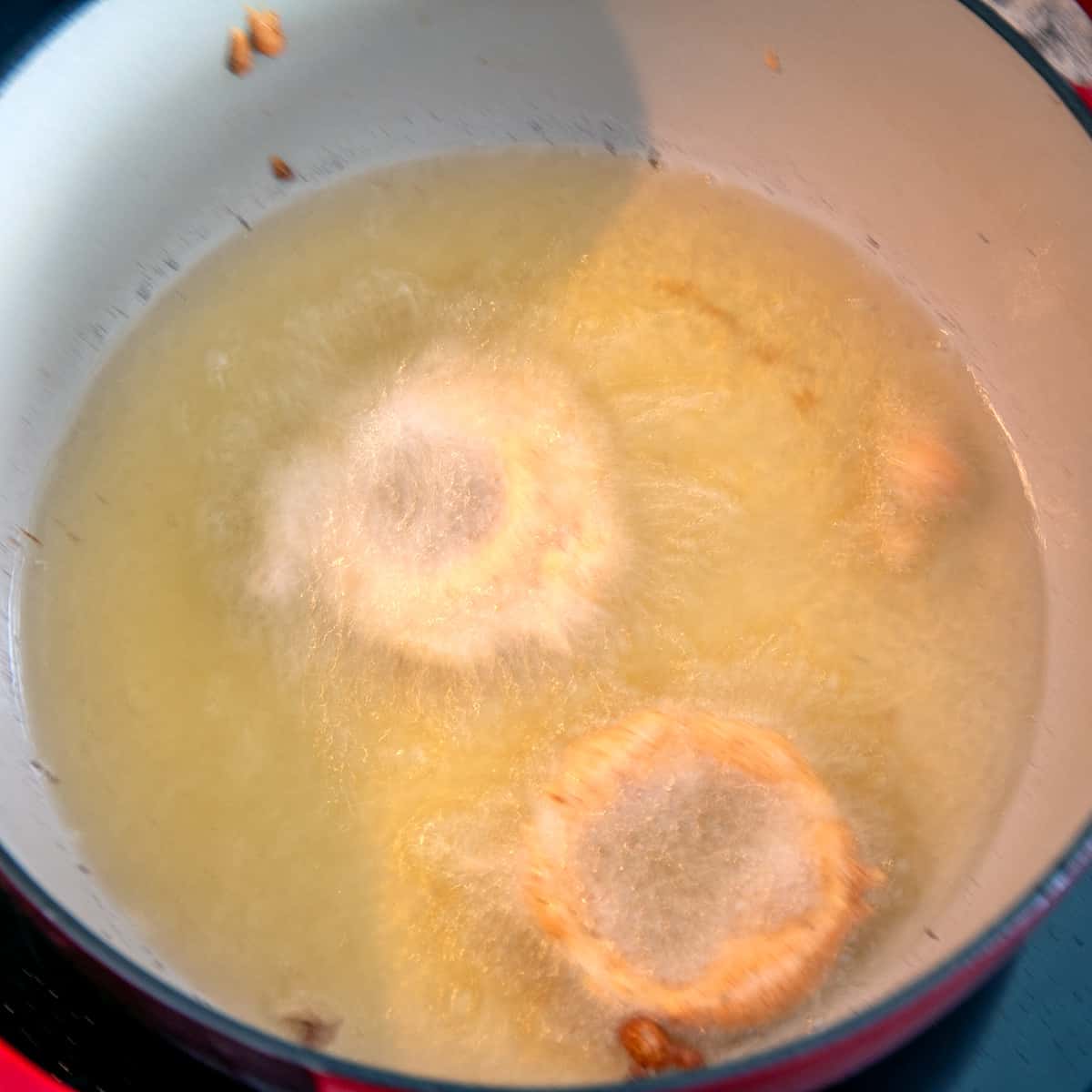 Two onion rings frying in oil.