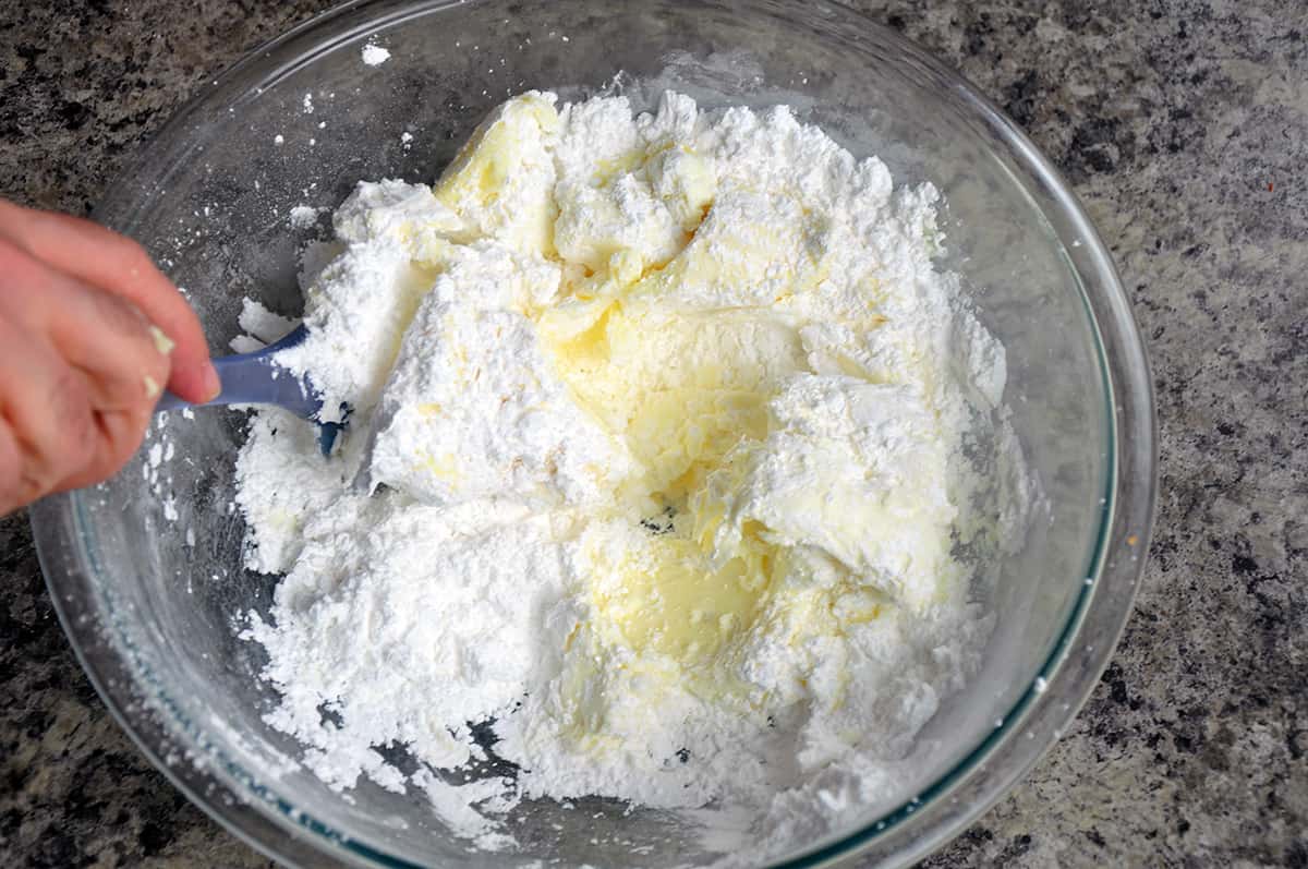 Mixing cream cheese frosting ingredients.