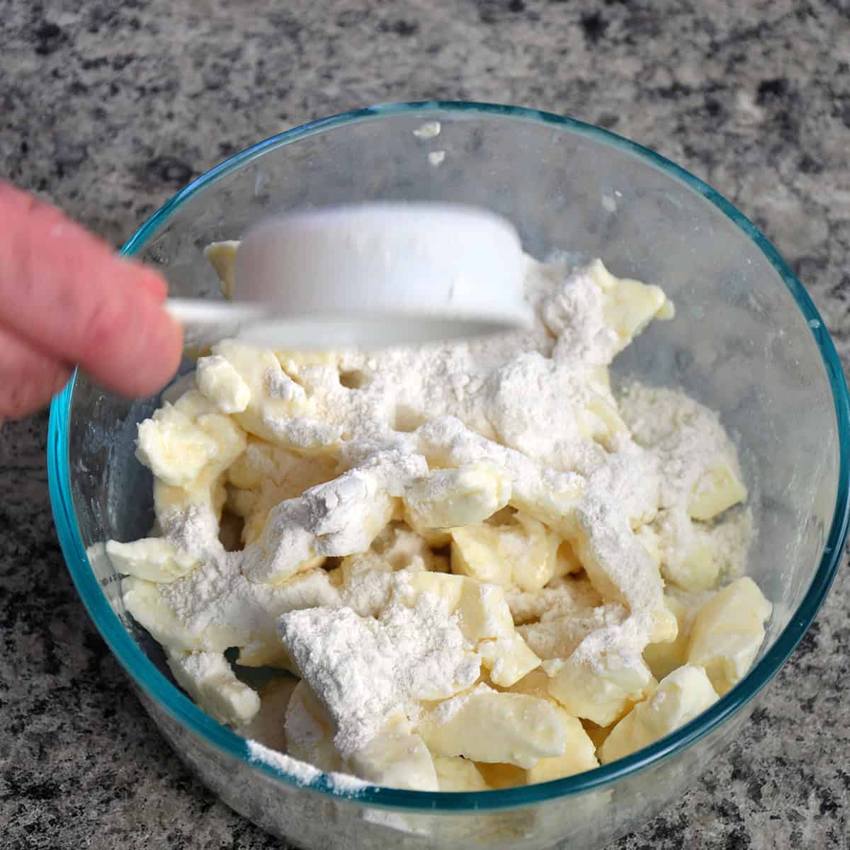 Chedder cheese curds in bowl with flour.