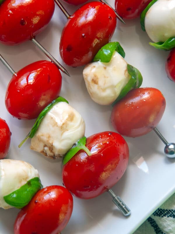 Caprese skewers on a white plate.