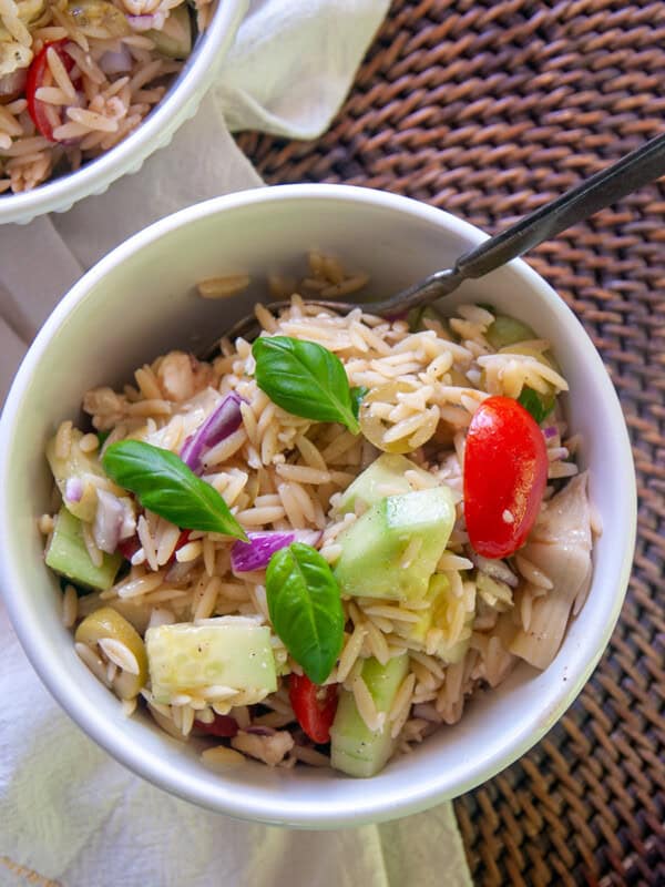 Fresh orzo salad in a white bowl.