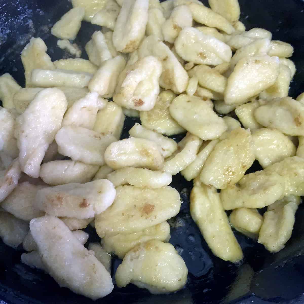 Frying flour dumplings in skillet with butter after boiling.