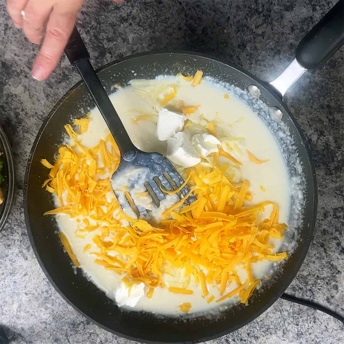 Cheeswe Sauce Cheddar cheese and cream cheese mixing into bechamel sauce.