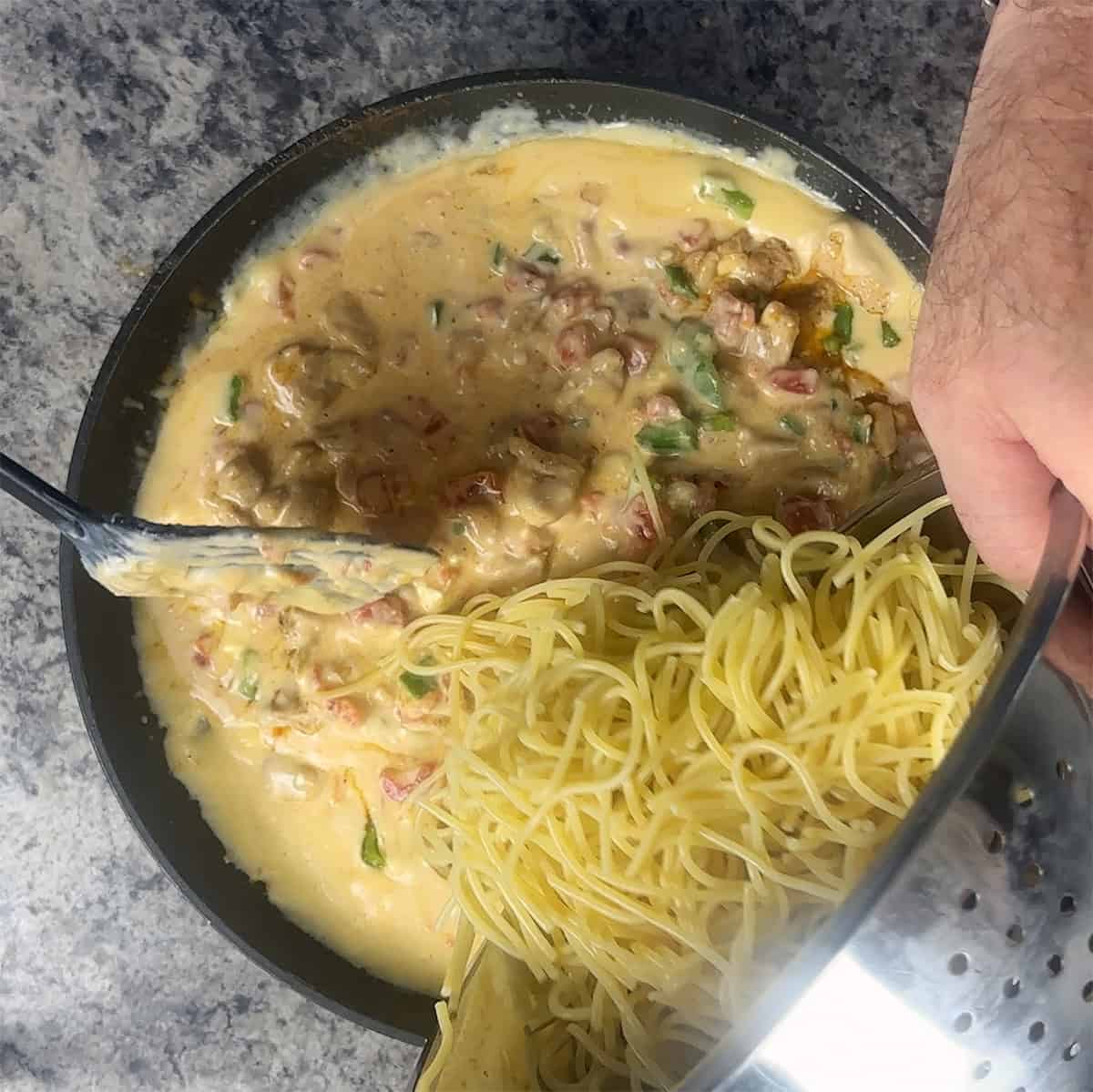 Mixing Everything Dumping spaghetti into cheese mixture.