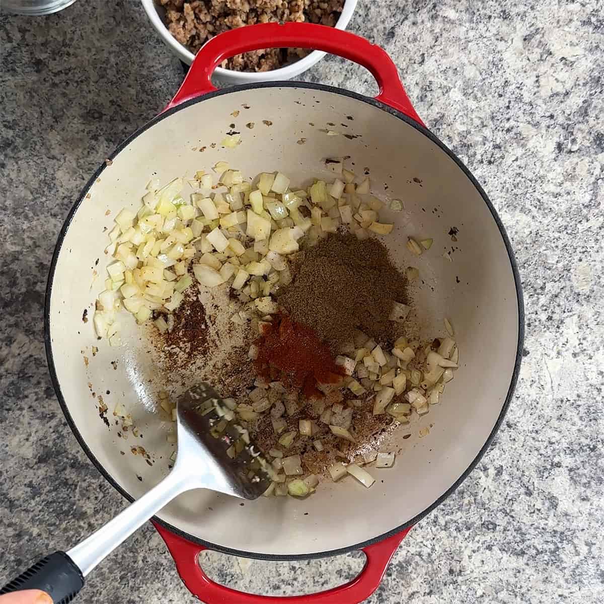 Onion, paprika, and garam masala in the bottom of a dutch oven.