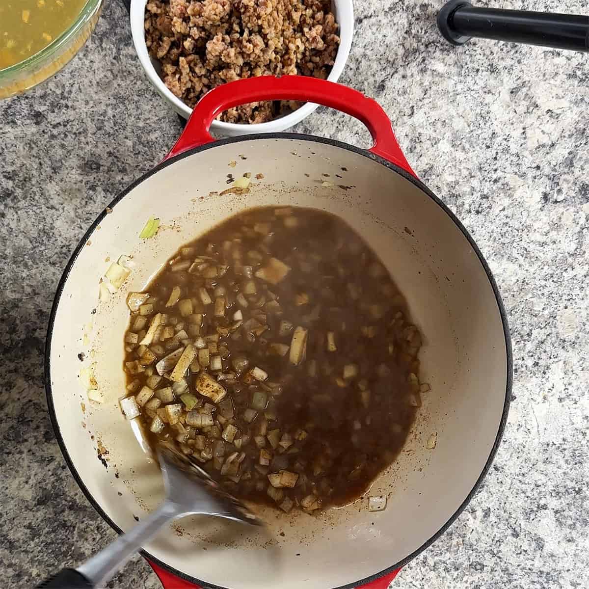 A bit of broth and onion at the bottom of a dutch oven.